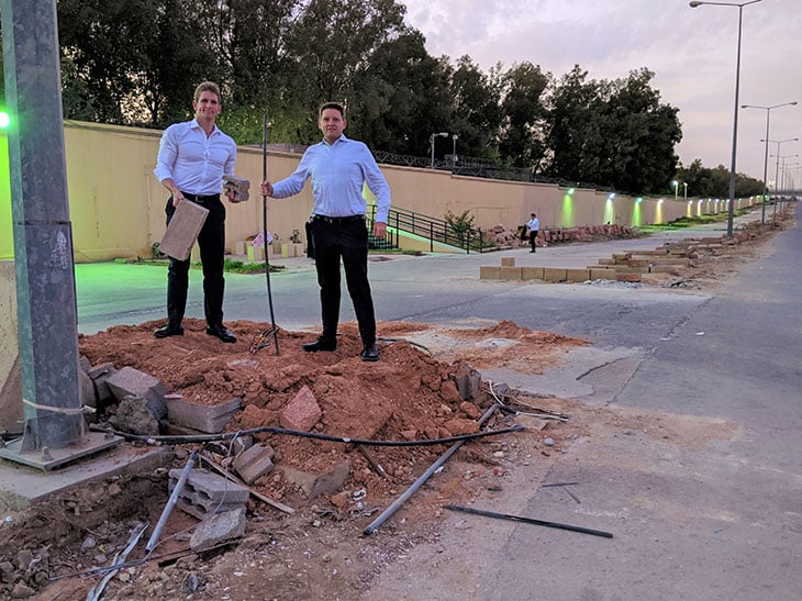 Two man standing on a rubble next to a sidewalk