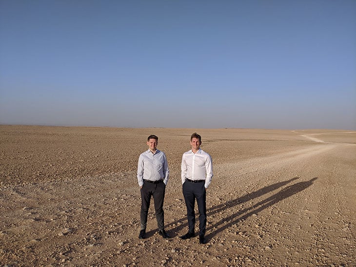 Two men standing in a desert