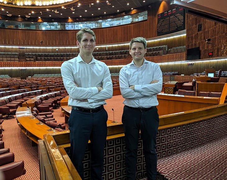 Two men standing inside a large parliament hall